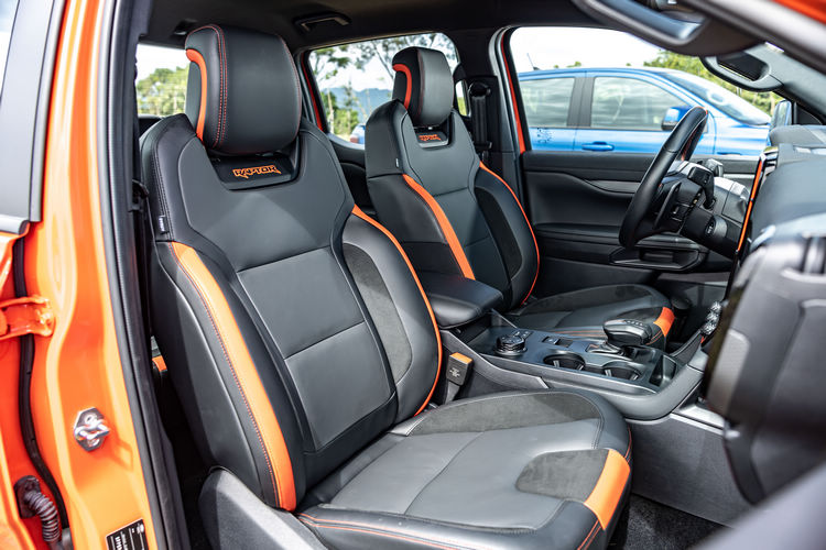 雙前座十向電動調整皮質賽車座椅和方向盤都搭配了橘紅色飾條與車縫線。