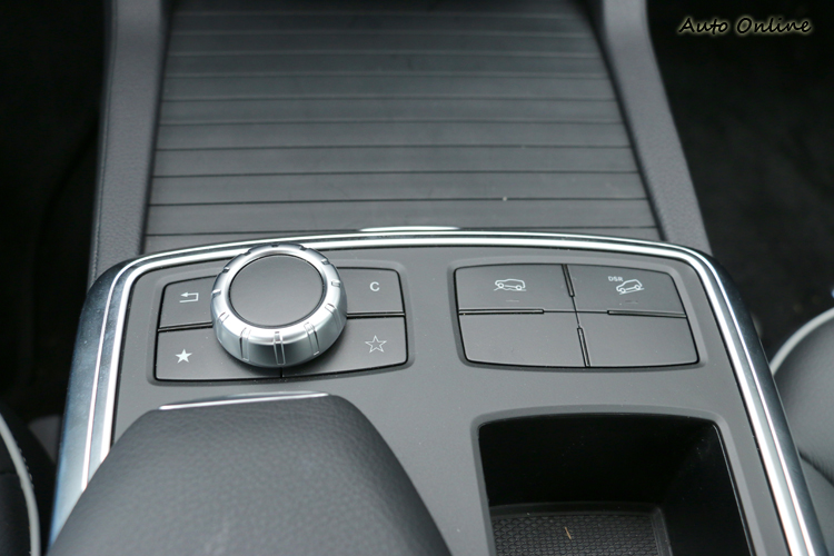 中央扶手前方有COMAND控制旋鈕,以及右方有陡坡緩降、越野功能按鍵。