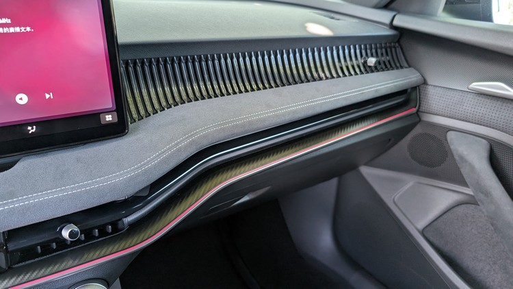 前方控台有著多層次的設計與材質使用,最上層的黑曜晶柱造型飾板直接將空調出風口融入其中